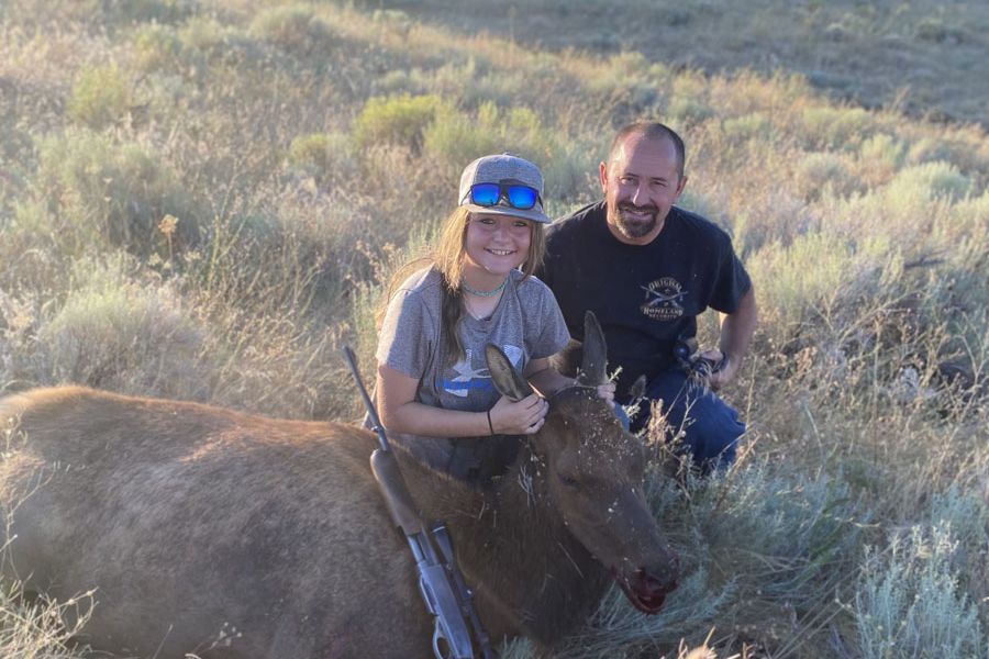 Young hunter and mentor with a cow elk